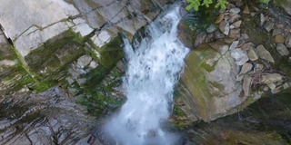 在夏天的热带雨林中，美丽的山河瀑布和白色的泡沫水从岩石悬崖上落下