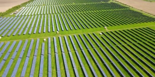 大型可持续发电厂鸟瞰图，有许多排太阳能光伏板，用于生产清洁的生态电能。零排放的可再生电力