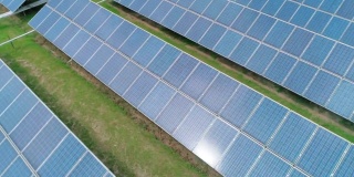 太阳能电池板鸟瞰图农场太阳能电池与太阳反射。可再生绿色替代能源概念。相机移动离开
