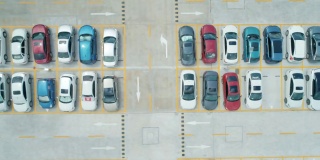 从空中俯瞰，停车场里停满了不同颜色的汽车。相机移动对吧