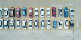 从空中俯瞰，停车场里停满了不同颜色的汽车。相机移动离开