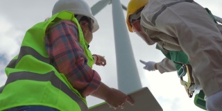 两名专业技术人员在风力发电机组工作。