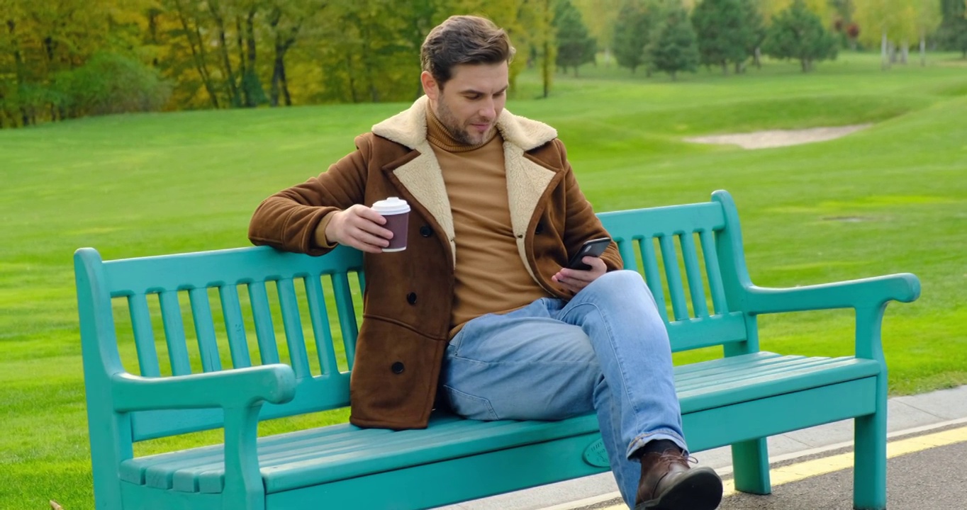 加拿大城市公园，商人在公园长椅上用手机喝咖啡