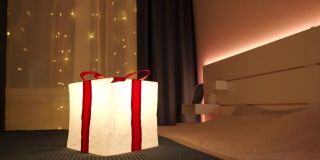 在夜晚，礼品盒灯的灯光照亮了装饰过的房间。生日、圣诞节、新年喜庆彩灯。