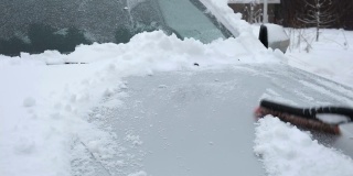 暴风雪过后，人们从车窗上刷下刚下的雪。在寒冷的冬天早晨，车主们的日常困难。汽车清洗窗户。冬天的季节。白色的雪。汽车护理。