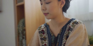 一个亚洲女人在互联网上播放音乐和视频通话。