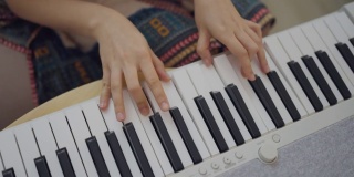 在家独自键盘钢琴爱好年轻女子练习钢琴。