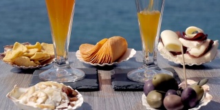 往杯子里倒饮料。夏天喝橙汁。海前美味的开胃菜。适合搭配薯片、橄榄、吐司、三明治和美味的开胃酒。