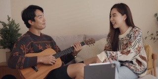 年轻男子和年轻女子在家里用社交媒体弹吉他唱歌