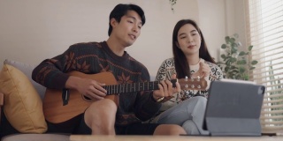 年轻男子和年轻女子在家里用社交媒体弹吉他唱歌