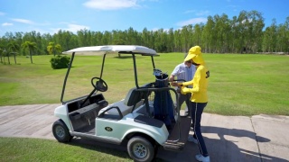 4K亚洲高级男子驾驶高尔夫球车在高尔夫球场与女球童高尔夫球草地视频素材模板下载