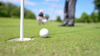 4K老年人高尔夫球手在球道上把高尔夫球打过一个洞视频素材模板下载