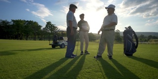 夏天的日落时分，高尔夫球场上，4K组亚洲男子高尔夫球手在比赛结束后握手