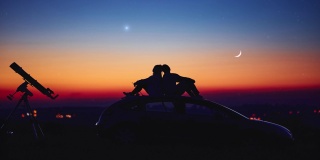一对夫妇用天文望远镜一起看星星。