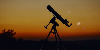 望远镜的剪影，星空和新月下的乡村。