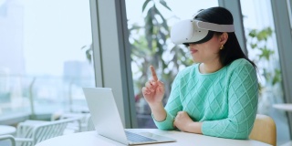 聪明迷人的亚洲女企业主戴着虚拟现实眼镜，在咖啡厅餐厅与专注于休闲的元时空会议，亚洲女企业主在咖啡厅使用oculus rift耳机