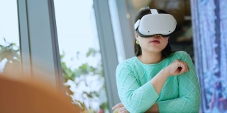 聪明迷人的亚洲女企业主戴着虚拟现实眼镜，在咖啡厅餐厅与专注于休闲的元时空会议，亚洲女企业主在咖啡厅使用oculus rift耳机
