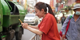 在泰国曼谷的夜市，一名4K亚洲妇女在使用智能手机旅行