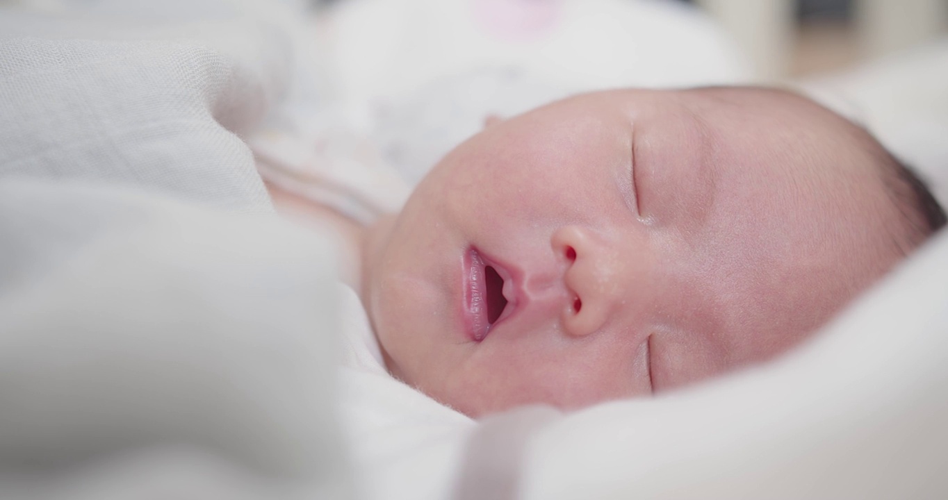 可爱的可爱的小新生儿的肖像脸婴儿在家里睡觉，幸福的新生儿在舒适的家在白天照明室内