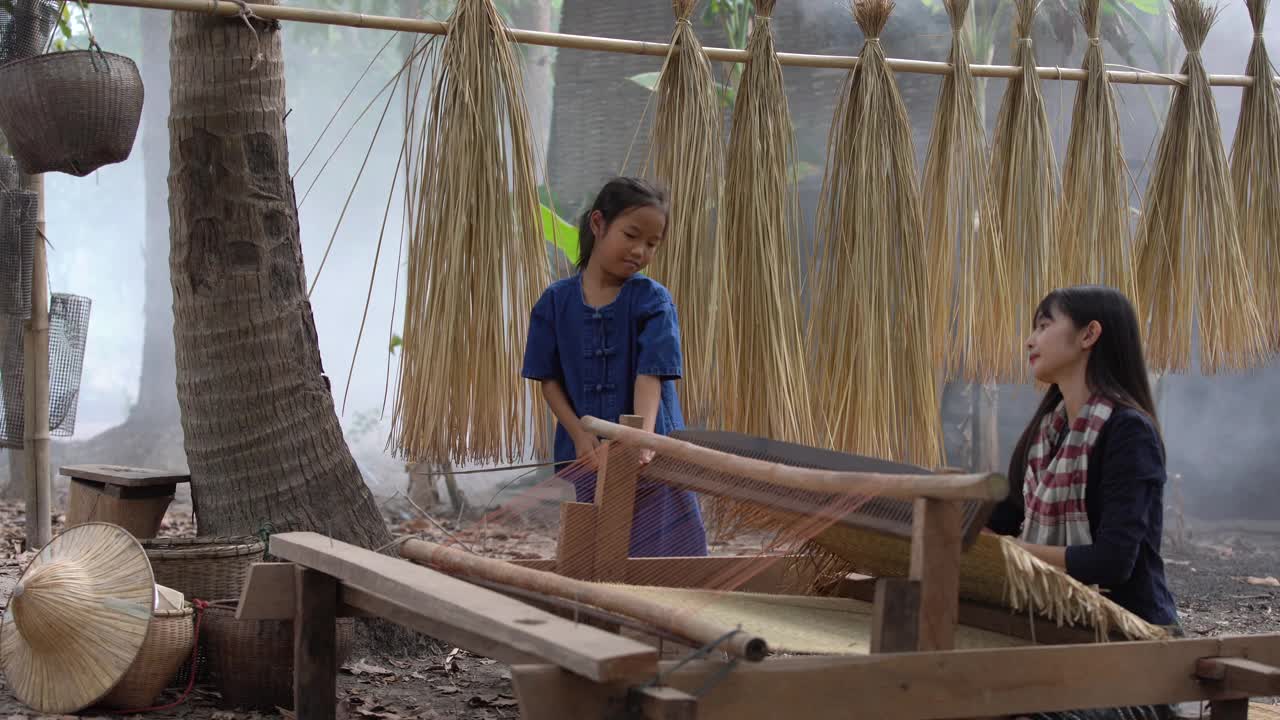 亚洲女孩织布席子。乡村女孩织布席子。Nong Khai,泰国。