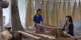 亚洲女孩织布席子。乡村女孩织布席子。Nong Khai,泰国。