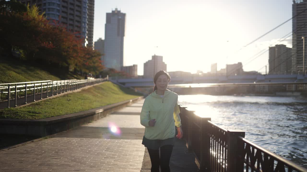 日落时分，女人在城市里奔跑，休息一下