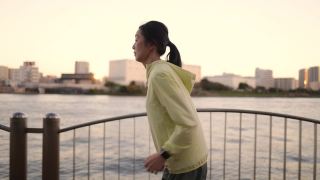 日落时分的东京，一名女子在河边奔跑视频素材模板下载