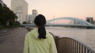 落日时分，东京，一名女子在河边奔跑的背影视频素材模板下载