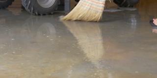 低角度:用稻草刷毛的扫帚扫去地板上的脏水。