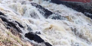 山中波涛汹涌的河流在石头之间。强大的河流量。沸腾和泡沫的水在山上。危险的春季洪水，气候变化。