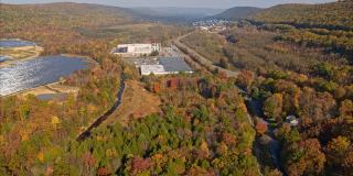 宾夕法尼亚州阿巴拉契亚山脉的大型太阳能农场，在一个多彩的秋天。航拍视频与平移和轨道摄像机运动。