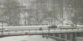 在爱沙尼亚的一个雪天，汽车沿着道路行驶