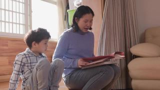 母亲和儿子在客厅里看书视频素材模板下载