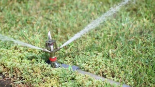 草坪自动洒水器，浇灌绿草。自动喷水灭火系统，慢动作视频素材模板下载