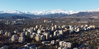 飞过智利首都圣地亚哥上空，背景是安第斯山脉。无人机的观点。