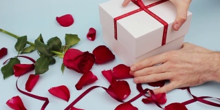 情人节快乐。礼物。红玫瑰花瓣和红丝带。礼物