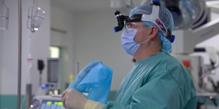 在手术室工作的医学专家。医生戴着医用口罩，头上戴着特殊设备在做手术。概要肖像。