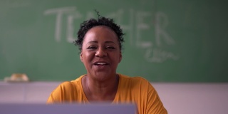 成熟的老师在教室里用笔记本电脑做在线课程