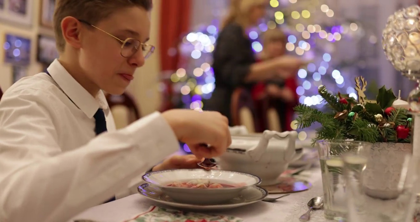 十几岁的男孩在圣诞夜的晚餐上吃罗宋汤