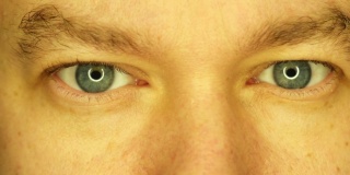 男性的特写眼睛被不同颜色的光照亮。