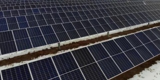 正面的太阳能电池板，没有阳光，在冬天的一天，地上有雪