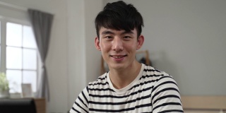 这是在卧室里通过电脑学习的亚洲帅哥的肩部照片。