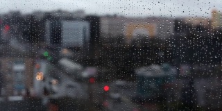 在雨天模糊的城市窗口视图。
