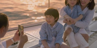 带着两个孩子的亚洲家庭乘船游玩。