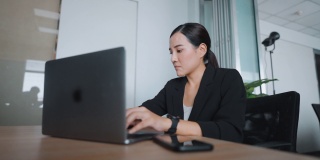 女商人使用笔记本电脑在家庭办公室的办公桌