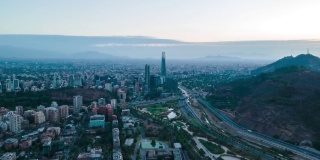 在智利首都圣地亚哥金融区，空中轨道上的日落超摄，道路上的交通和汽车经过——无人机拍摄