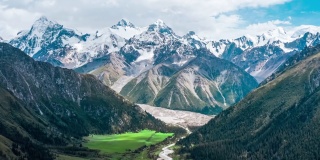 空中拍摄的新疆绿色草原和雪山景观