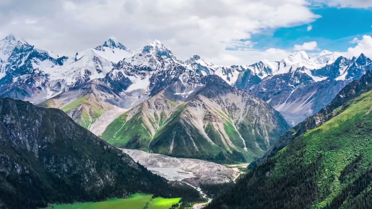 空中拍摄的新疆绿色草原和雪山景观