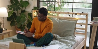 年轻的黑人男学生在家里学习