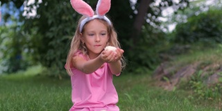 小女孩在复活节户外和小鸡玩